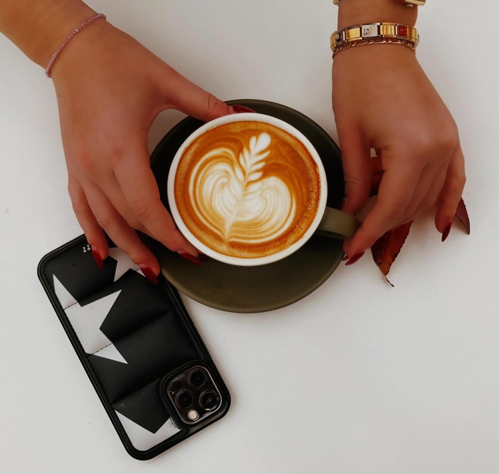 Latte with rosetta art held in hand